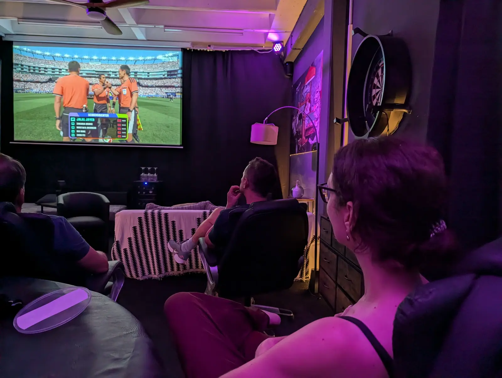 Gäste erleben gemeinsam eine Übertragung auf der großen Leinwand